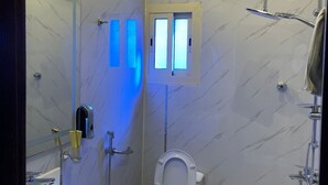 A modern bathroom with a toilet, sink, and shower.