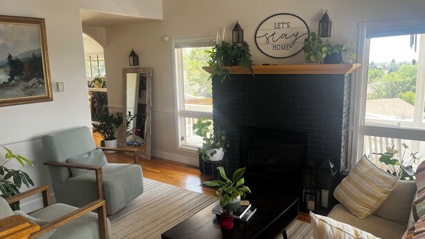 A living room with a fireplace, a sofa, a chair, and a coffee table. - Spacious 5-bedroom house in Cheyenne with AC, fitness room, outdoor space (Cheyenne)