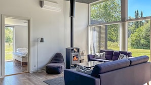 A modern living room with a sofa, a fireplace, and large windows. - Pet friendly home in Fur with WiFi (Fur)