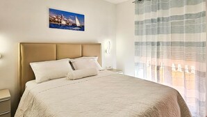 A neatly made bed with a headboard, a bedside table, a wall-mounted lamp, and a painting of a coastal scene. - 1 bedroom lovely apartment in Rab Barbat (Rab Barbat)