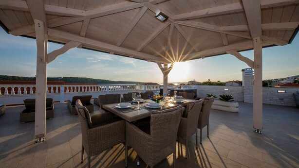 An outdoor dining area with a pergola, wicker furniture, and a view of the sea. - 1 bedroom lovely apartment in Rab Barbat (Rab Barbat)