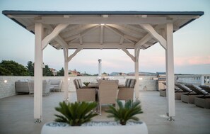 A covered outdoor seating area with wicker furniture, a grill, and potted plants. - 1 bedroom lovely apartment in Rab Barbat (Rab Barbat)