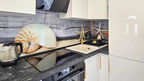 A modern kitchen with a unique backsplash, a sink, and a stove. - 1 bedroom lovely apartment in Rab Barbat (Rab Barbat)