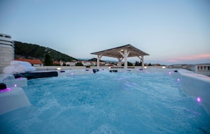 A hot tub with a gazebo in the background, surrounded by buildings and hills. - 1 bedroom lovely apartment in Rab Barbat (Rab Barbat)