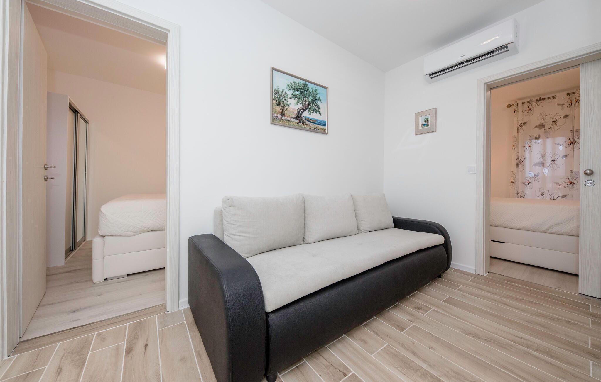 Una habitación moderna con sofá, cama y aire acondicionado.
