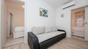 Una stanza moderna con un divano, un letto e un condizionatore d'aria.