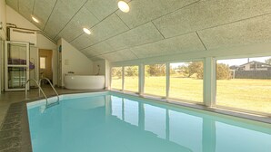 En swimmingpool med udsigt til en græsplæne og et spabad.