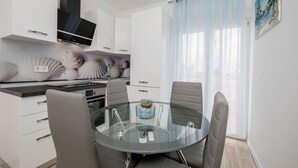 A modern kitchen with white cabinets, a built-in oven, and a flat-screen TV. - Amazing apartment in Rab Barbat with WiFi (Rab Barbat)