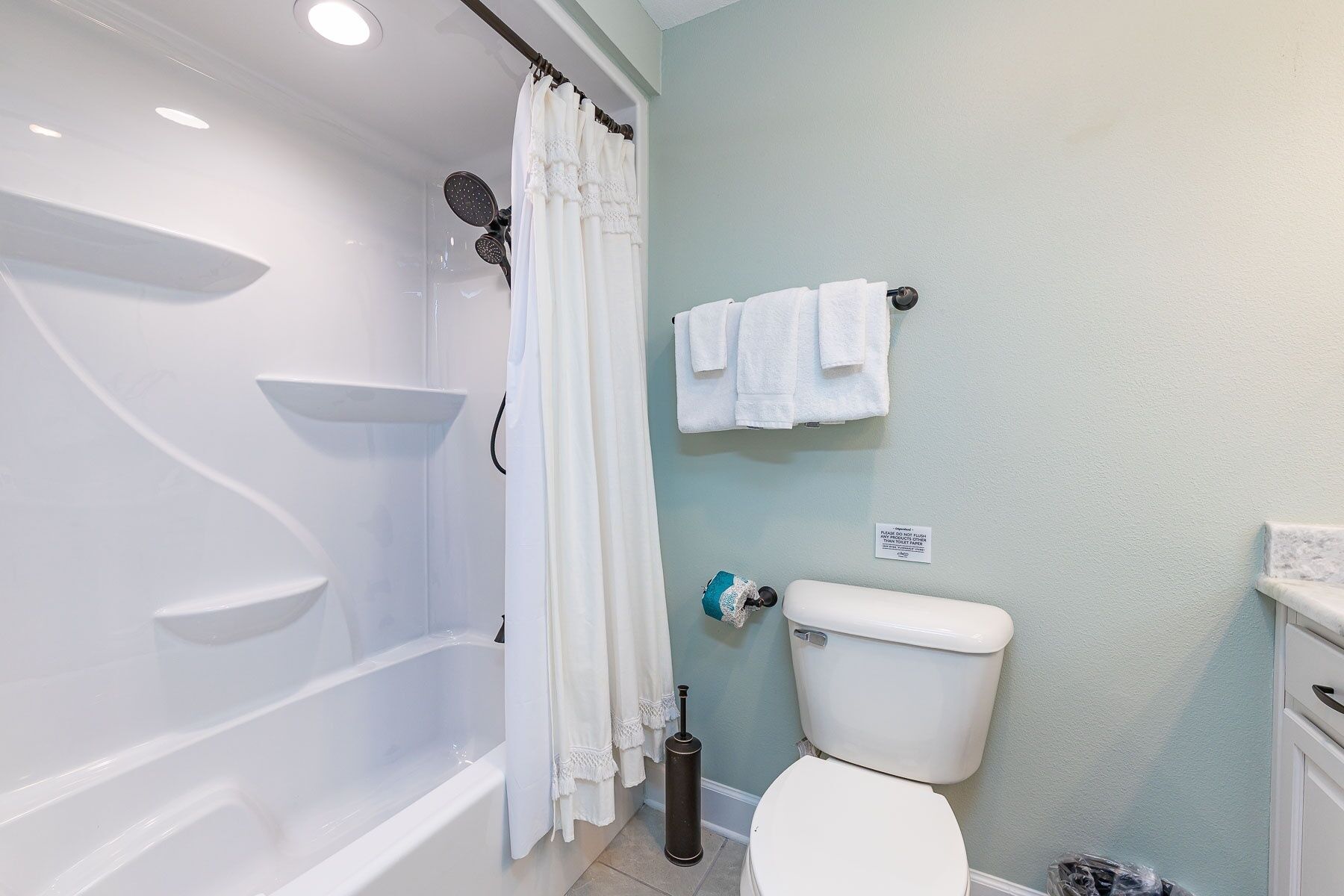 A bathroom with a bathtub, toilet, and towel rack.