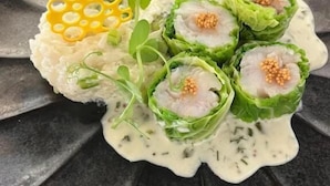 A plate with food items, including a green leafy wrap and a yellow decorative element. - Hôtel Le Castanea (Roannes-Saint-Mary)