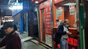 Fachada con letreros rojos que indican un servicio de cambio de divisas.