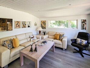 Ein modernes Wohnzimmer mit zwei Sofas, einem Couchtisch und einem schwarzen Bürostuhl.
