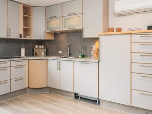 Eine moderne Küche mit weißen Schränken, einem Einbauofen und einer Edelstahl-Spüle.