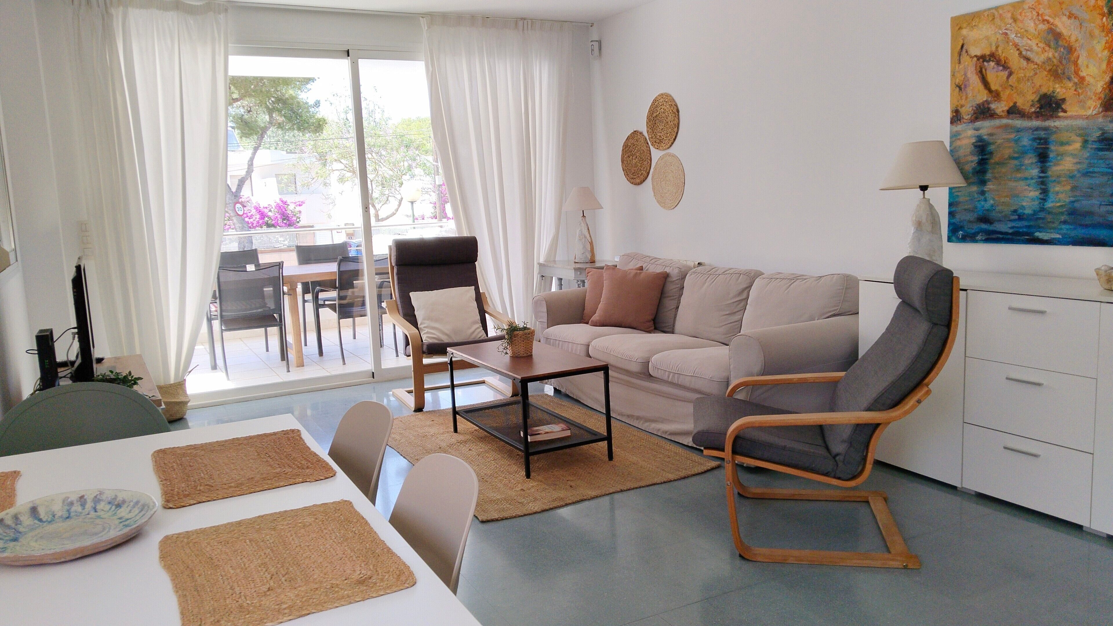 Una sala de estar con un sofá, una silla, una mesa de centro y una mesa de comedor.