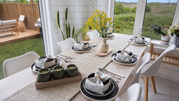 An outdoor dining area with a table set for four, surrounded by chairs, with a view of the countryside. - The Triple Nest - Where Your Summer Story Begins (Hamilton)