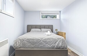 Une chambre à coucher avec un lit, une fenêtre et un radiateur.