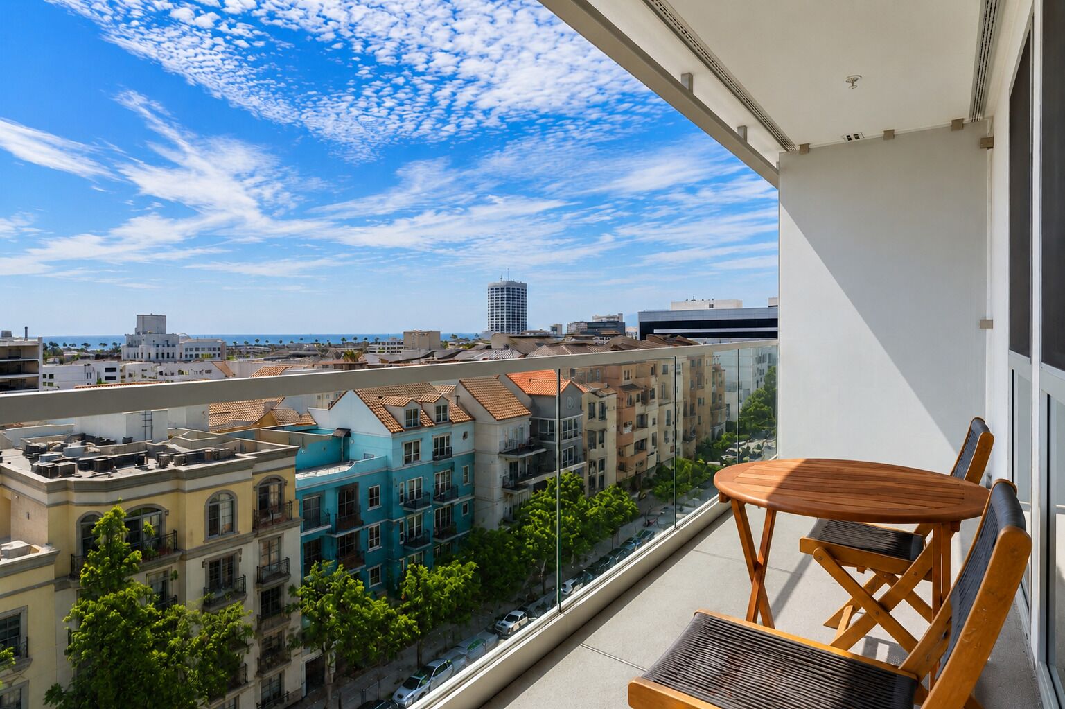 A balcony with a view of a cityscape, including buildings and a clear sky.