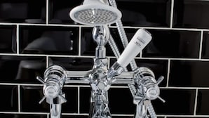 A chrome shower with a handheld showerhead and two control knobs labeled 'HOT' and 'COLD'. - Luxury St Margarets Flat Richmond Free Parking (Twickenham)