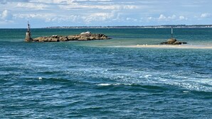 A coastal scene with rocky outcrops and a lighthouse.