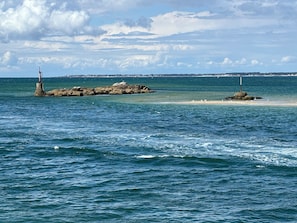 A coastal scene with rocky outcrops and a lighthouse.