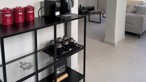 En moderne hotellobby med en kaffebar, et fladskærms-tv og et siddeområde med udsigt.