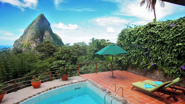 A swimming pool with a view of a mountain, a green umbrella, and a lounge chair. - Private Pool Villa with Iconic Piton Views (Soufrière)