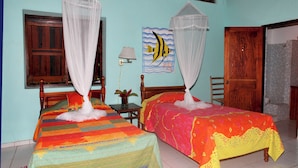 A room with two beds, each with a canopy, a wall painting, a window, and a door. - Private Pool Villa with Iconic Piton Views (Soufrière)