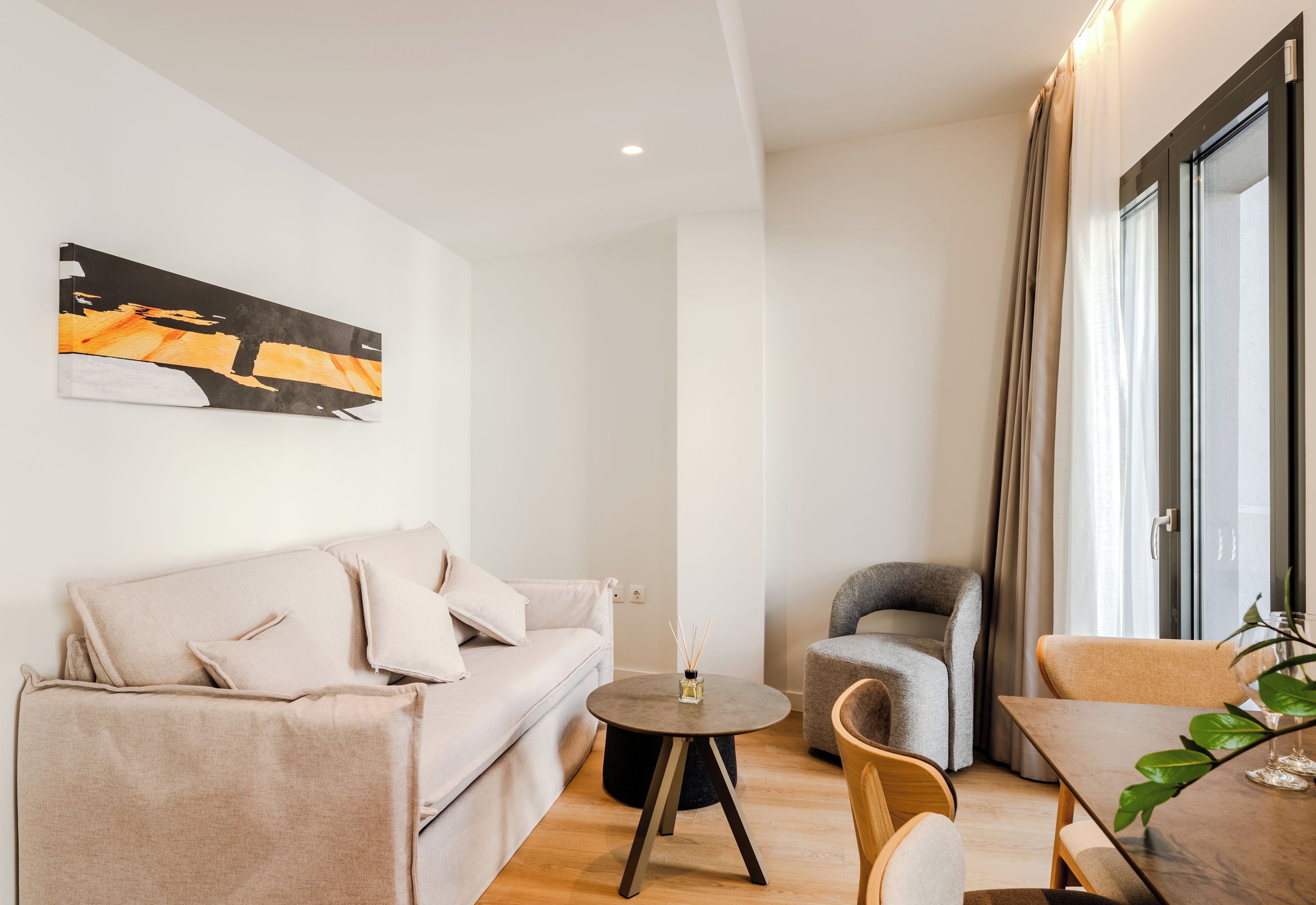 Un salon moderne avec un canapé, une table ronde et un fauteuil.