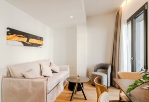 Un salon moderne avec un canapé, une table ronde et un fauteuil.