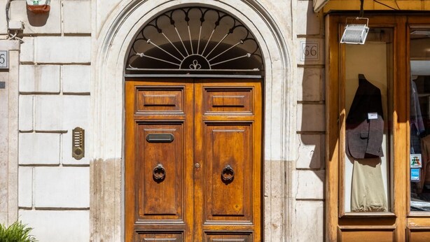 A double wooden door with a fanlight above, a small window with shutters, and a potted plant to the left. - One Bedroom Apartment (ROMA)