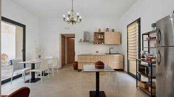 Una cocina moderna con comedor, una araña y un refrigerador.