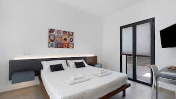 Ein modernes Hotelzimmer mit Bett, Nachttischen, Schreibtisch, Fernseher und einem großen Fenster.