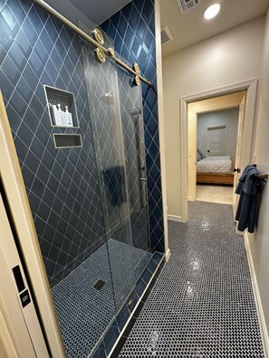 A modern bathroom with a shower, a toilet, and a sink.