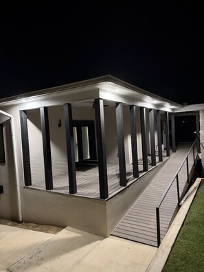 Un espace extérieur abrité, doté d’une rampe menant à l’entrée d’un bâtiment.