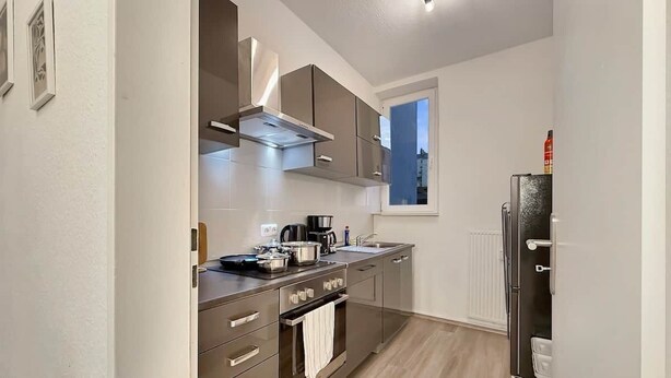 Cocina moderna con electrodomésticos de acero inoxidable, una ventana y vistas a la ciudad.