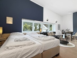 Een moderne slaapkamer met een groot bed, een bureau en uitzicht op de omgeving.