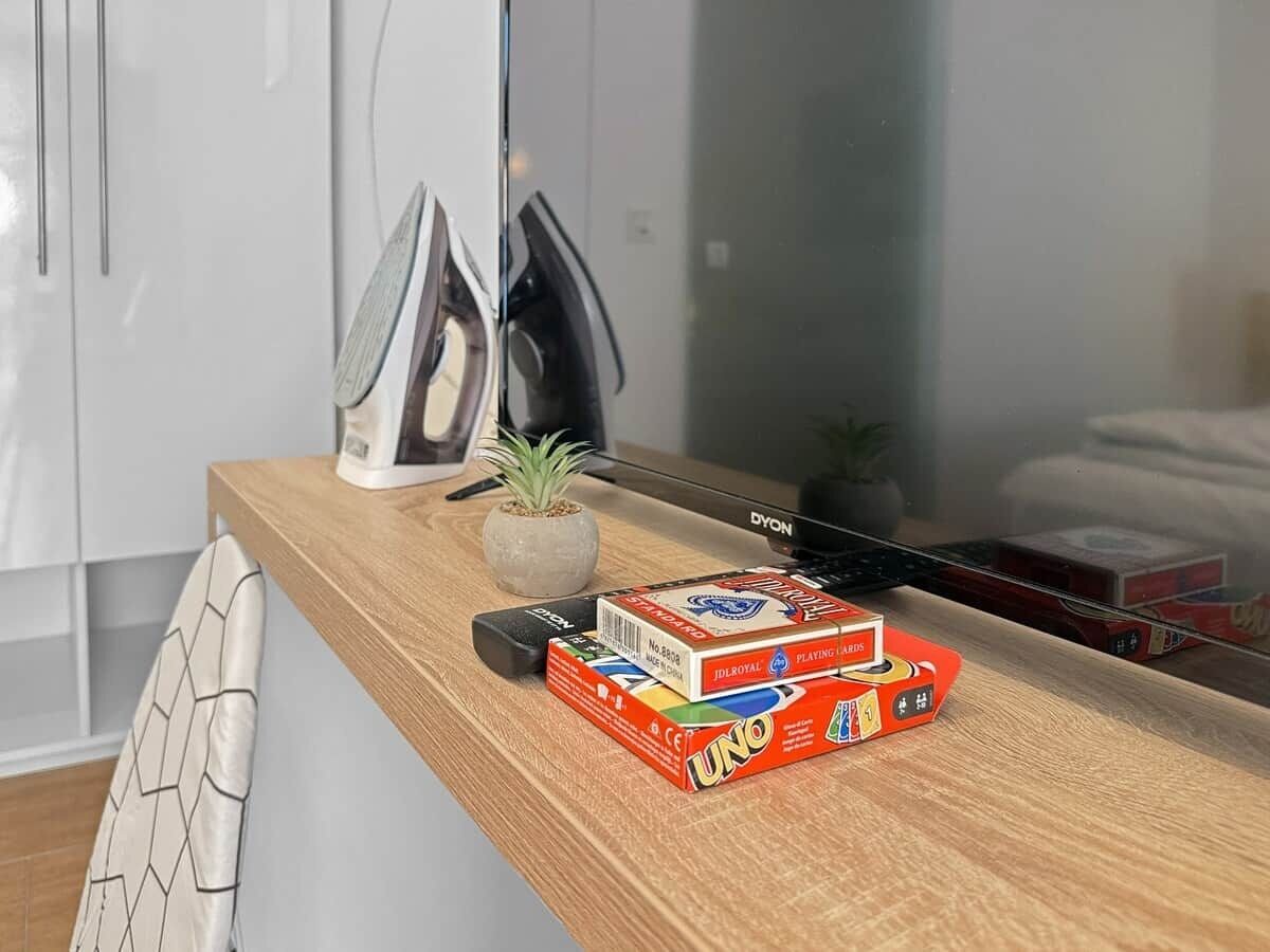Eine Holzauskładung mit einer Kaffeemaschine, einem Blumentopf und einem Stapel UNO-Karten.