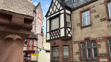 Une vue de rue avec des maisons traditionnelles à colombages, un ciel dégagé et une route bien visible.