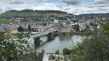 Une ville traversée par une rivière, avec un pont et des collines en arrière-plan.