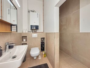 Un baño moderno con bañera, inodoro y zona de ducha.
