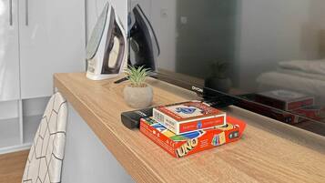 A wooden kitchen counter with a coffee maker, a potted plant, and a stack of UNO cards.
