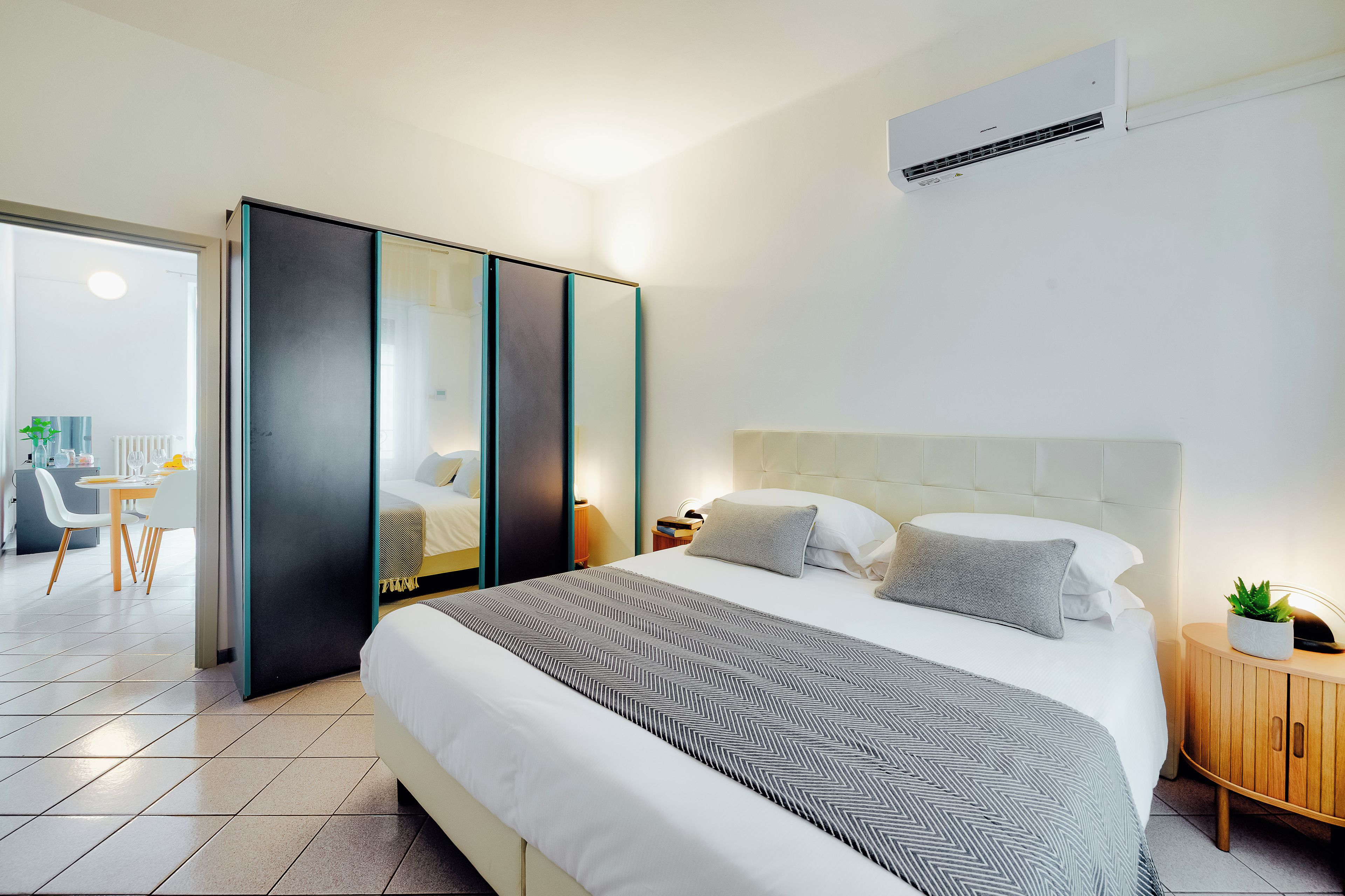 Una camera d'albergo moderna con un letto grande, un'area pranzo separata e vista sulla città.
