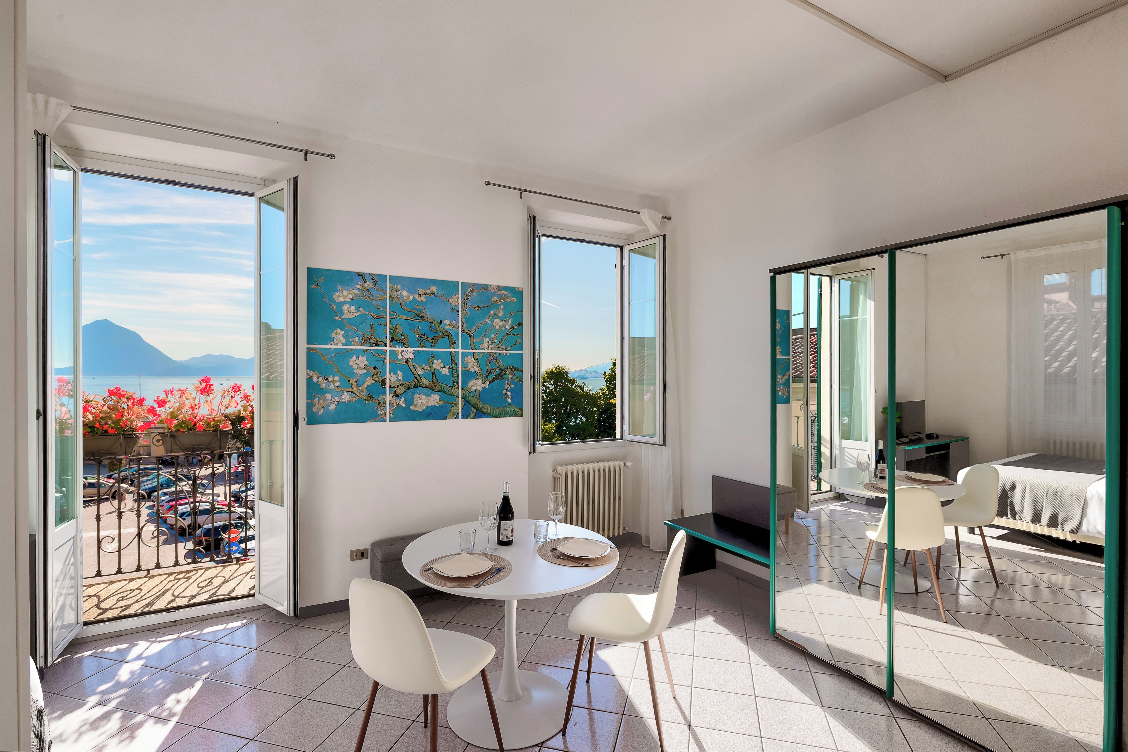 Un intérieur moderne comprenant un coin repas, un tableau et une vue sur l’extérieur.