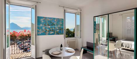 A modern interior with a dining area, a painting, and a view of the outdoors.