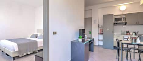 Una habitación de hotel moderna con cama, escritorio y kitchenette.