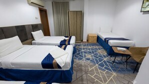 A hotel room with two beds, a sofa, a small table, and a wardrobe. - Zad Ajyad (Makkah)