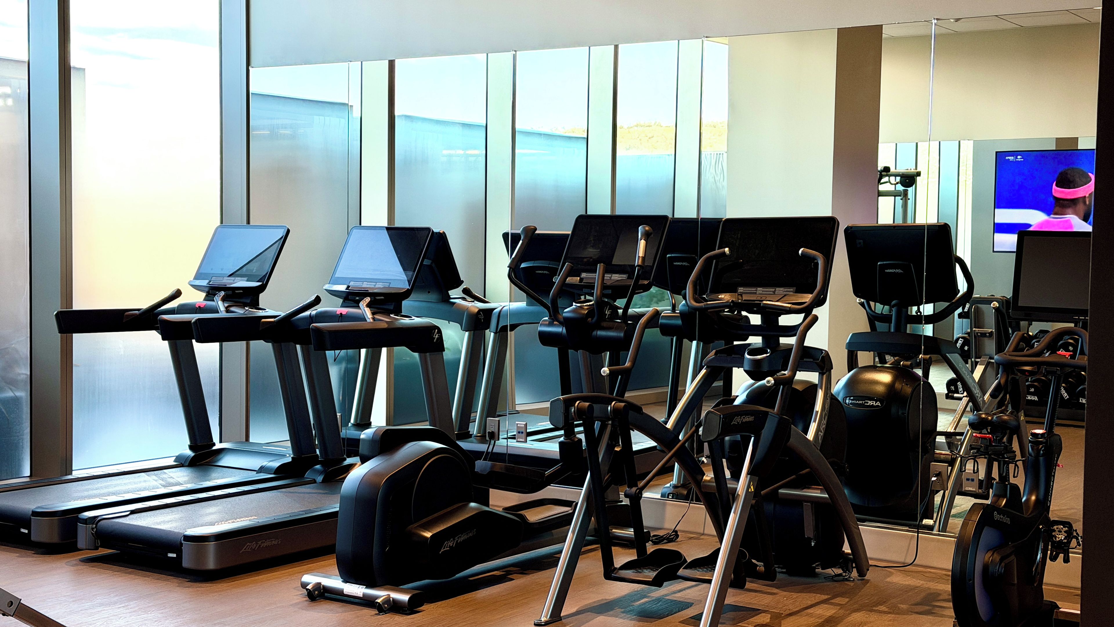 A gym with treadmills, elliptical machines, and stationary bikes.