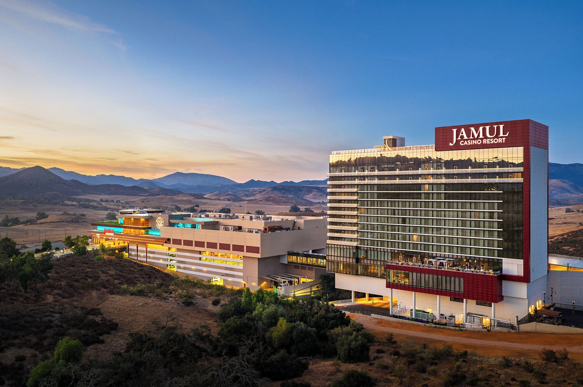 A modern hotel with a prominent casino sign, a multi-story structure, and a view of the surrounding landscape.