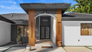 Ein modernes Haus mit Veranda, Briefkasten und einem kleinen Garten.