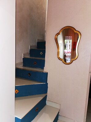 Eine Treppe mit blauen Stufen und einem Spiegel an der Wand.
